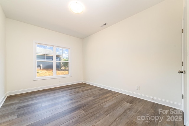 empty room with dark hardwood / wood-style flooring