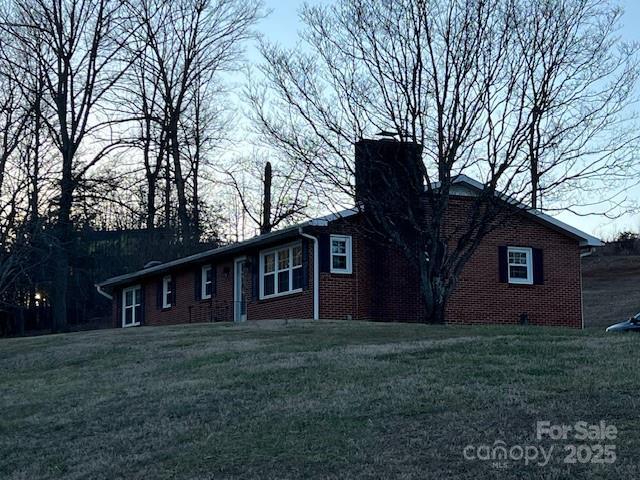 single story home featuring a front lawn