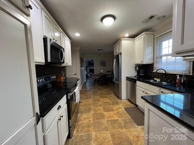 kitchen featuring white cabinetry, appliances with stainless steel finishes, and sink