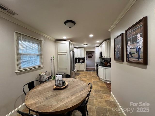 dining space with ornamental molding