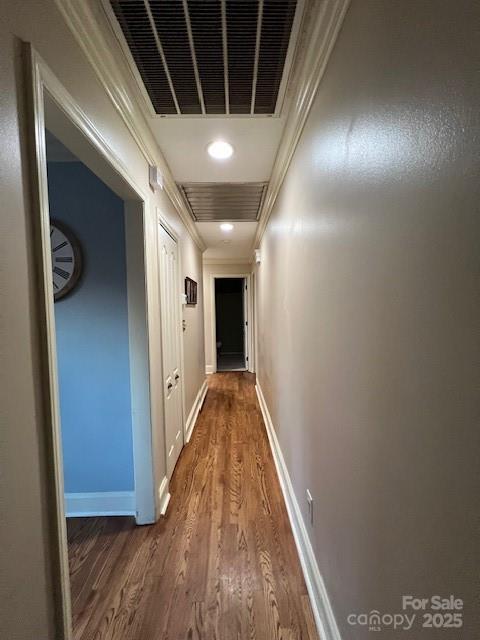 corridor featuring dark wood-type flooring and ornamental molding