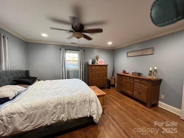 bedroom with crown molding, ceiling fan, and wood-type flooring