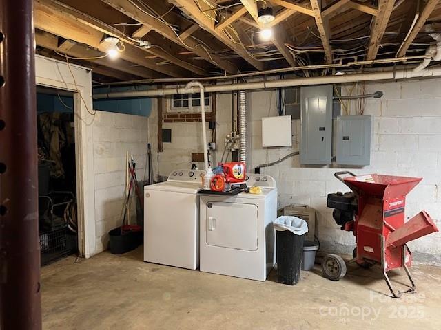 basement with electric panel and washing machine and dryer