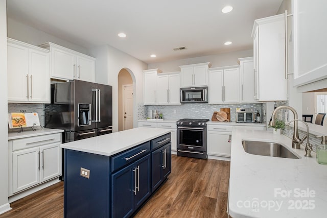 kitchen featuring sink, appliances with stainless steel finishes, a kitchen island, white cabinets, and blue cabinets