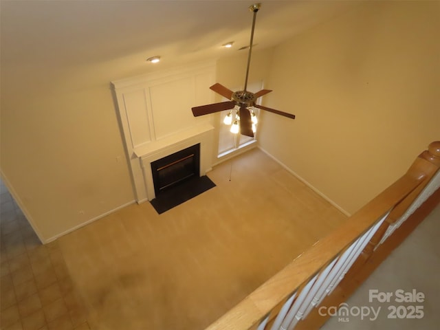 unfurnished living room with light colored carpet and ceiling fan