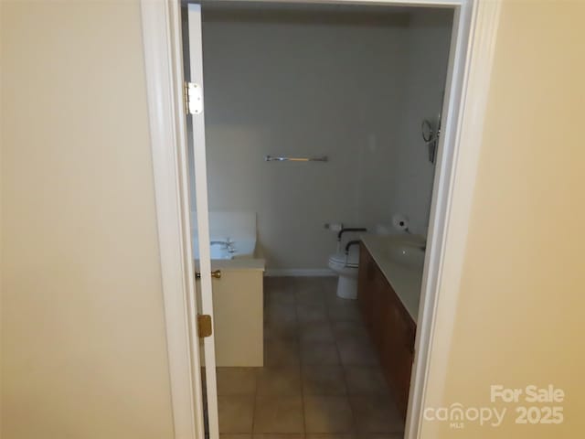 bathroom featuring vanity, tile patterned floors, a bathing tub, and toilet