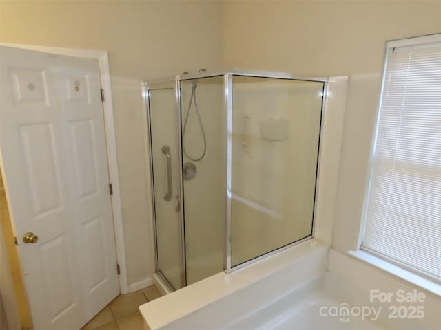 bathroom featuring walk in shower and tile patterned flooring