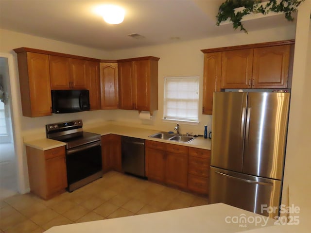 kitchen with light tile patterned floors, sink, and black appliances