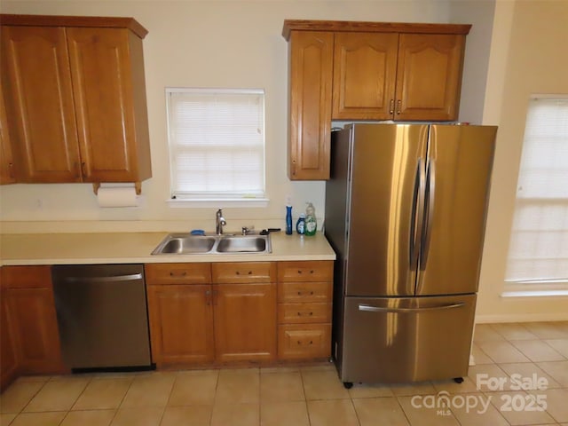 kitchen with sink, light tile patterned floors, and stainless steel appliances