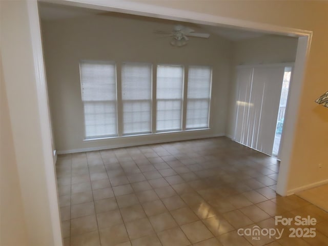 empty room with ceiling fan and light tile patterned flooring