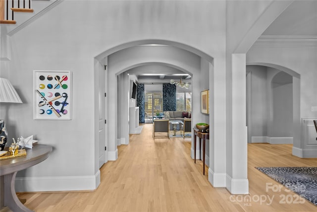 corridor featuring ornamental molding and light hardwood / wood-style flooring