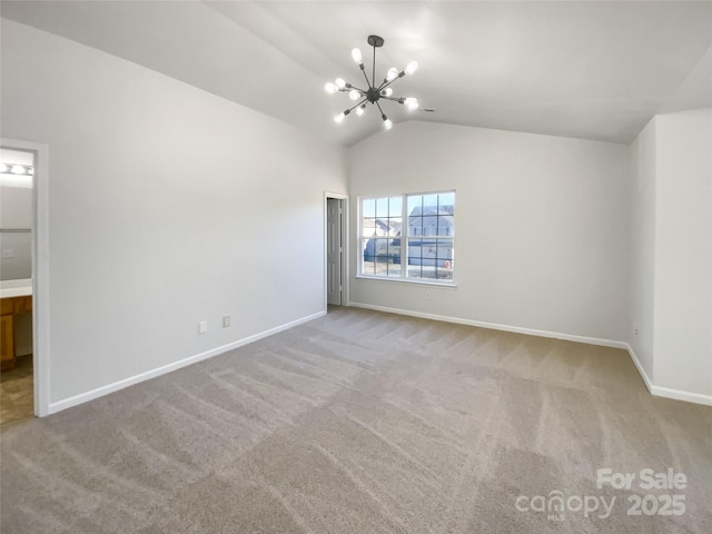 spare room with lofted ceiling, light colored carpet, and an inviting chandelier