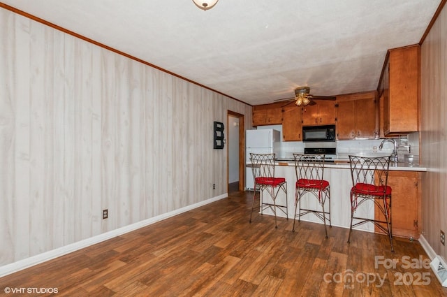 kitchen with a breakfast bar, white refrigerator, dark hardwood / wood-style flooring, kitchen peninsula, and ceiling fan