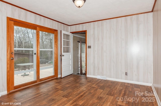 spare room featuring crown molding and dark hardwood / wood-style flooring