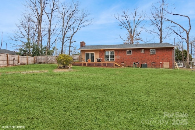 rear view of property with central air condition unit and a lawn