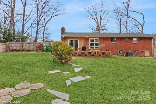 back of property with cooling unit, a wooden deck, and a lawn