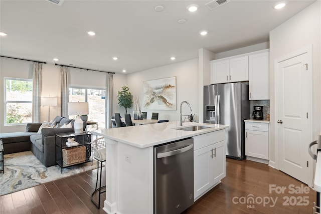 kitchen featuring white cabinetry, appliances with stainless steel finishes, sink, and a kitchen island with sink