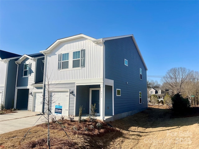 view of front of property featuring board and batten siding, concrete driveway, and a garage