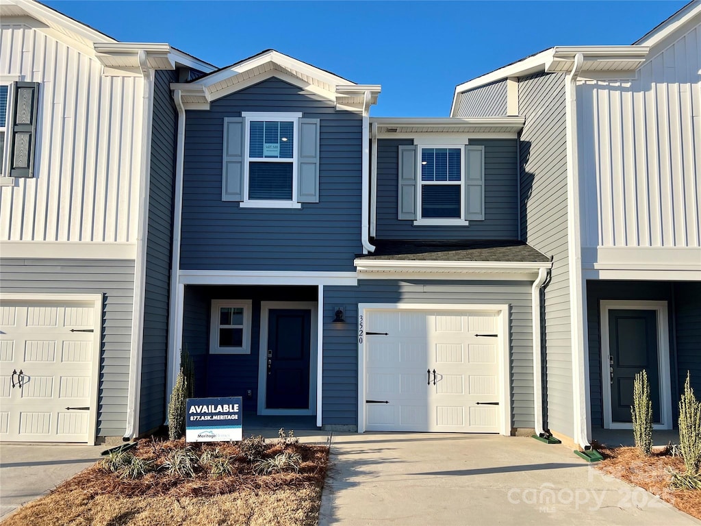 multi unit property featuring a garage and concrete driveway