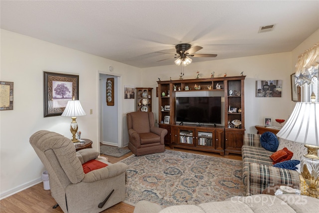 living room featuring ceiling fan and light hardwood / wood-style flooring