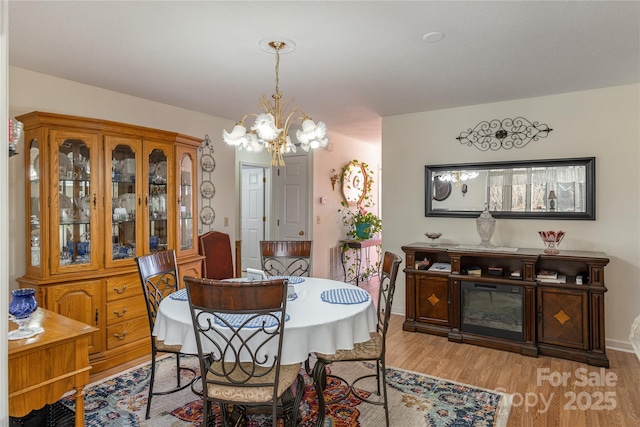 dining space with an inviting chandelier and light hardwood / wood-style floors