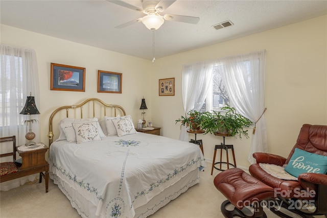 carpeted bedroom with ceiling fan and multiple windows