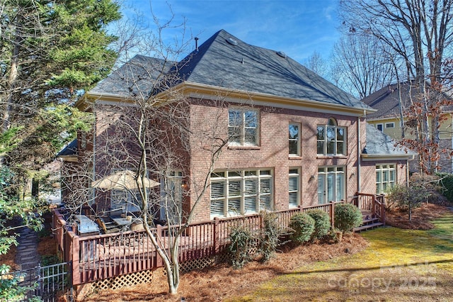 rear view of house featuring a wooden deck