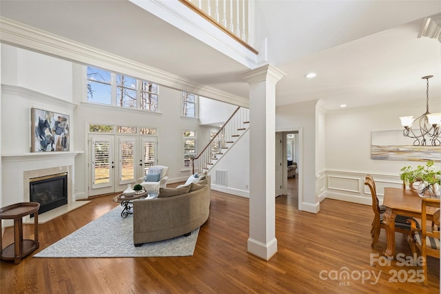 living room with crown molding, a notable chandelier, and hardwood / wood-style flooring