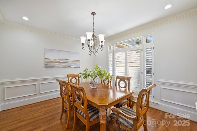 dining area featuring a notable chandelier, crown molding, and wood-type flooring