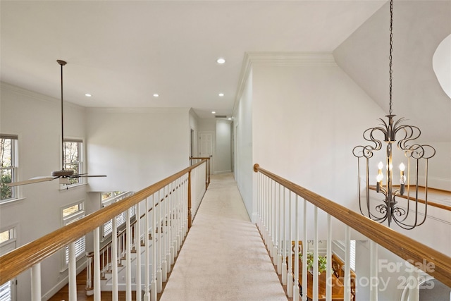 hall with crown molding and a chandelier