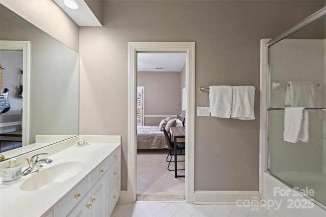 bathroom with tile patterned floors, vanity, and bath / shower combo with glass door