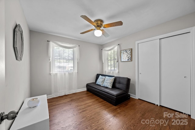 living area featuring dark hardwood / wood-style floors and ceiling fan