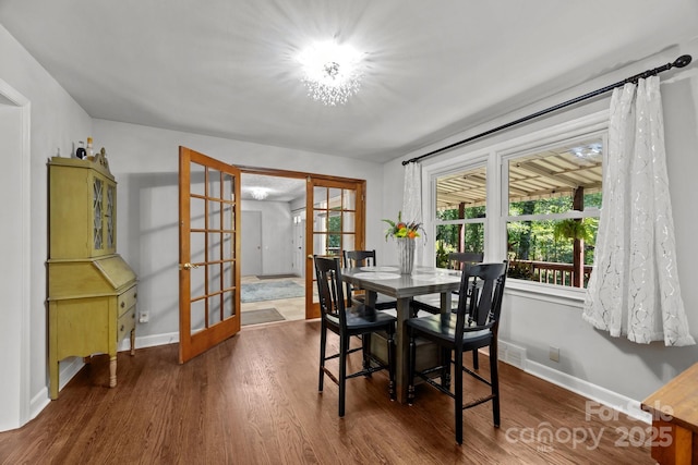 dining room with french doors, baseboards, and wood finished floors