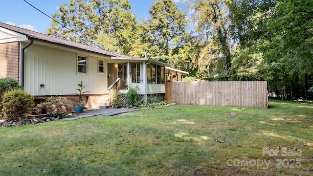 view of yard featuring fence and a sunroom