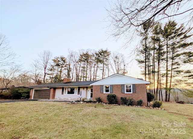 ranch-style house featuring a front lawn, an attached garage, brick siding, and a chimney