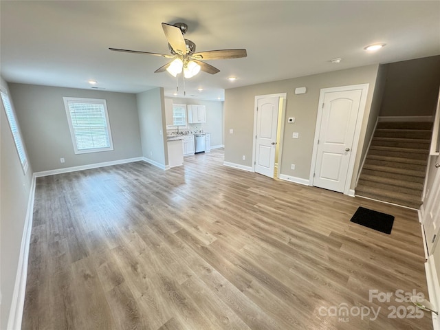 unfurnished living room with ceiling fan and light hardwood / wood-style floors