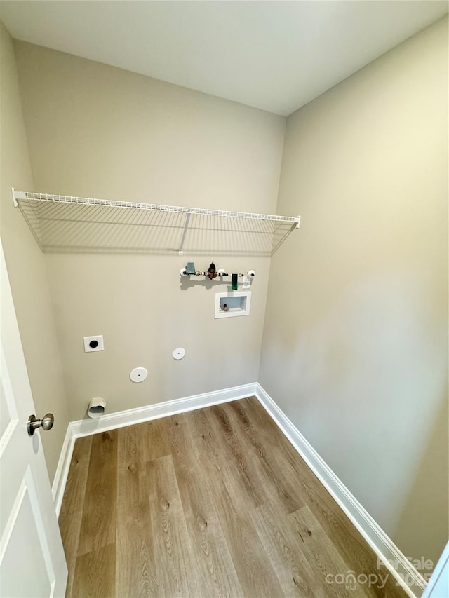 laundry room with hardwood / wood-style flooring, washer hookup, hookup for an electric dryer, and hookup for a gas dryer