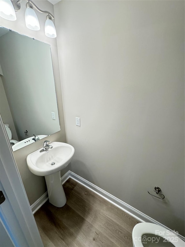 bathroom featuring wood-type flooring and toilet