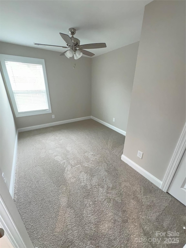 carpeted spare room with ceiling fan