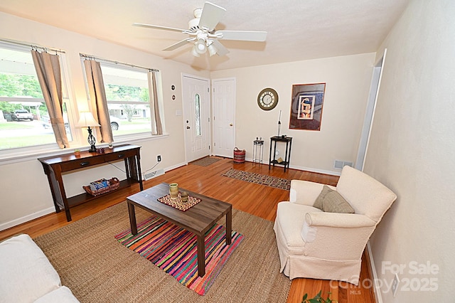 living room featuring hardwood / wood-style floors and ceiling fan