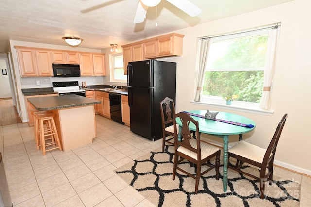 kitchen with light brown cabinetry, light tile patterned floors, black appliances, and a kitchen island