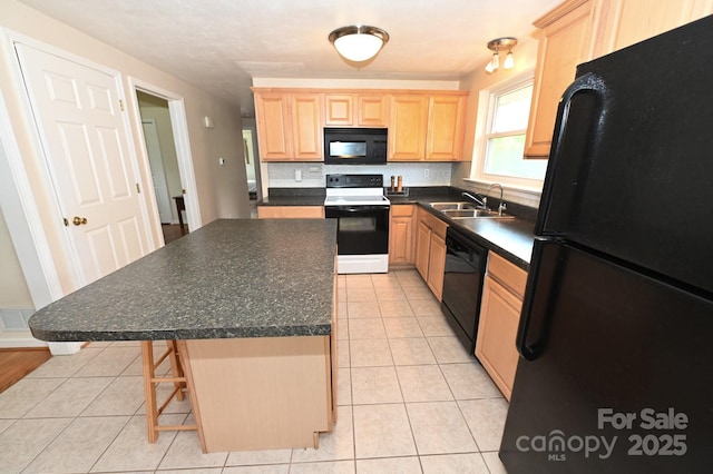 kitchen with sink, a breakfast bar, a center island, black appliances, and light brown cabinetry