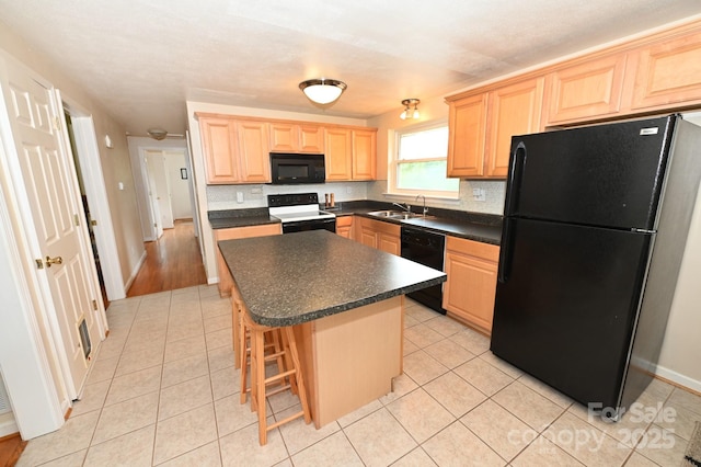 kitchen with backsplash, a center island, a breakfast bar area, and black appliances