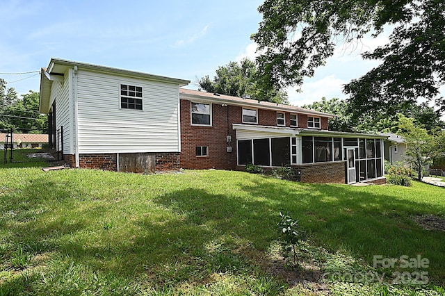 back of property with a sunroom and a lawn