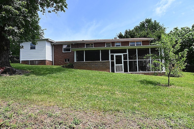 back of property with a sunroom and a lawn