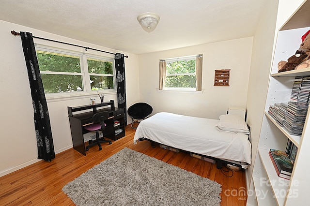 bedroom with light hardwood / wood-style floors and a textured ceiling