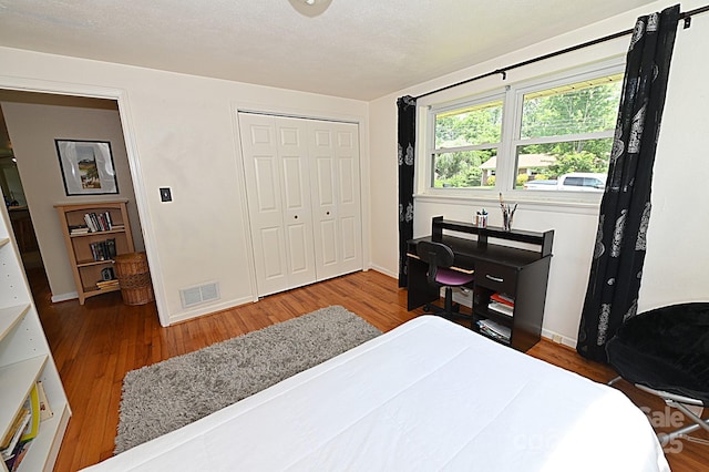 bedroom with wood-type flooring and a closet