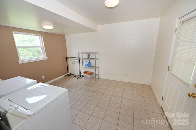 laundry room with washing machine and dryer and light tile patterned floors