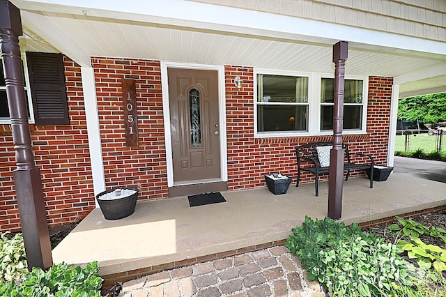 view of exterior entry with a porch