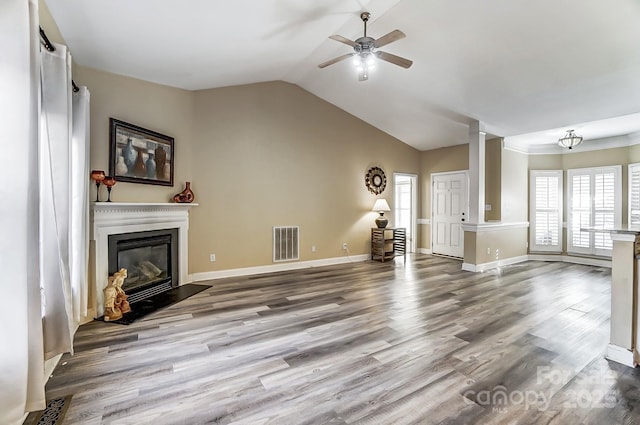 unfurnished living room with decorative columns, wood-type flooring, vaulted ceiling, and ceiling fan